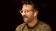 Der Komponist Sean Shepherd mit einem kabellosen Kopfhörer (Montage) © commons.wikimedia.org//Cabrown224 Foto: Cabrown224