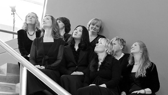 Schwarzgekleidete Chorsängerinnen beim Fotoshooting auf einer Treppe sitzend © NDR Chor Foto: Kristien Daled