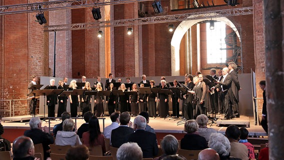 Konzertszene: Der NDR Chor auf der Bühne der St. Georgen-Kirche in Wismar. In der Mitte: Chordirektor Philipp Ahmann. © NDR Chor Foto: Kristien Daled