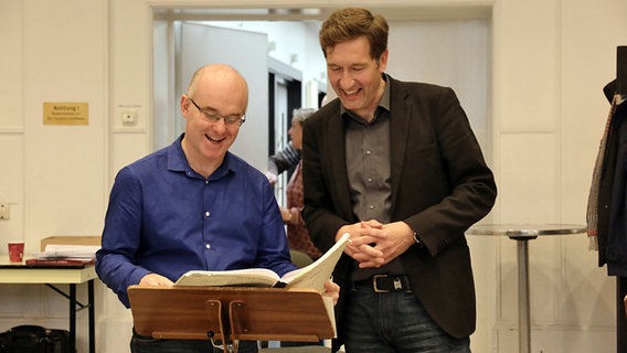 Laurence Cummings und Robert Blank lachend vor einem Notenpult © NDR Chor Foto: Kristien Daled