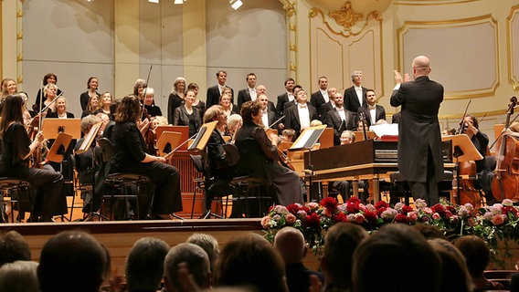 Konzertszene: Der NDR Chor und das FestspielOrchester Göttingen auf der Bühne der Laeiszhalle. Dirigent Laurence Cummings applaudiert dem Chor. © NDR Chor Foto: Kristien Daled