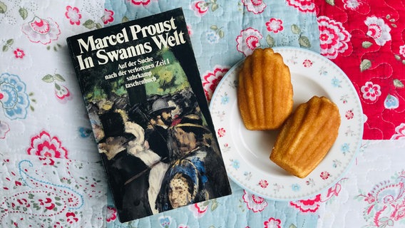 Das Proust-Buch "Auf der Suche nach der verlorenen Zeit" mit einem Teller Madeleines. © NDR 