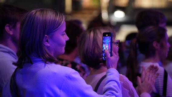 Eine Zuschauerin macht Fotos mit ihrem Handy. © NDR Foto: Jan-Philipp Baumgart