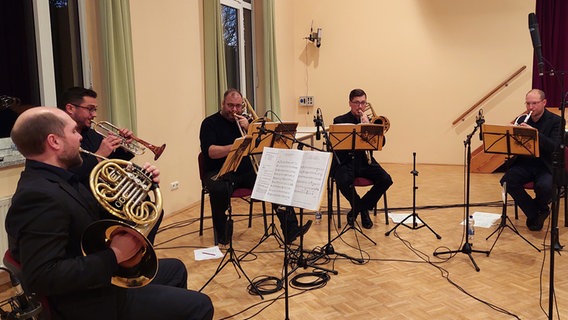 Blechbläser sitzen auf Stühlen und spielen ein Weihnachtslied. © NDR Foto: Arne Schirrmacher