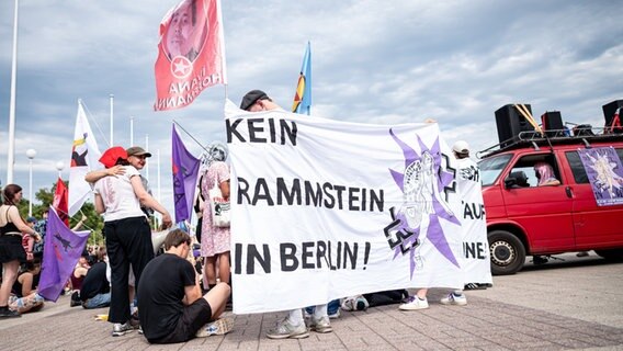 Teilnehmer der Demonstration "Kein Rammstein-Konzert in Berlin!" stehen vor dem Olympiastadion. © dpa Foto: Fabian Sommer