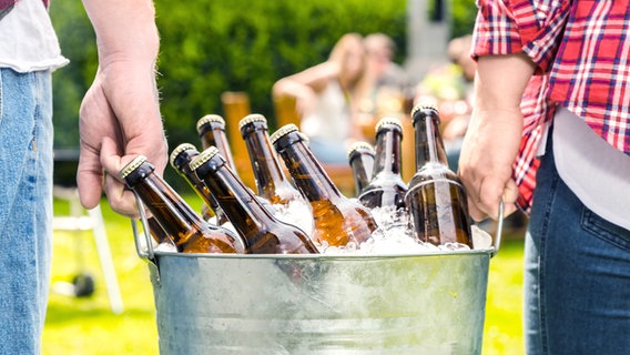 Männer tragen einen Eimer mit eisgekühlten Bier. © fotolia Foto: karepa