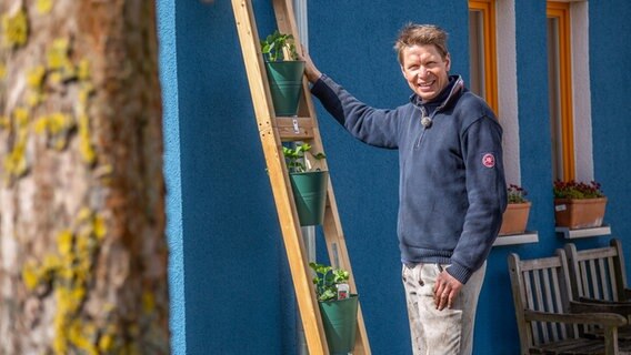 Peter Rasch steht vor einem vertikalen Erdbeergarten © NDR Foto: Udo Tanske