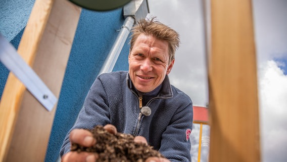 Peter Rasch hält Pflanzenerde in den Händen © NDR Foto: Udo Tanske