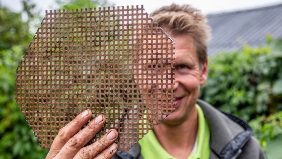 Peter Rasch hält sich ein mit Löchern versehenes Metallstück vors Gesicht © NDR Foto: Udo Tanske