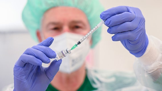 Ein Arzt zieht eine Spritze mit einem Corona-Impfstoff auf. © picture alliance / dpa Foto: Bernd Weißbrod