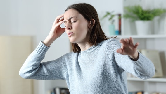 Frau mit Kreislaufproblemen fasst sich an Kopf und sucht nach Balance (Bild: colourbox.de) © colourbox.de 