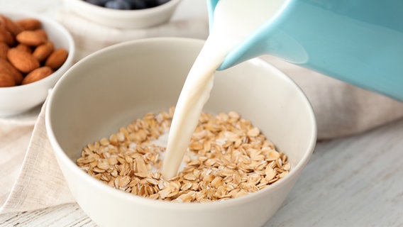 Milch wird in eine Schüssel mit Haferflocken gegossen. © fotolia.com Foto: Africa Studio