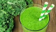 Grünkohl-Smoothie mit zwei Strohhalmen in einem Glas. © fotolia Foto: Jenifoto