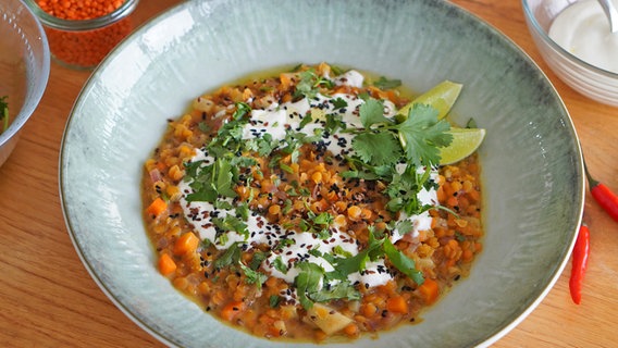 Dal mit roten Linsen, Joghurt-Dip und Koriander auf einem tiefen Teller © NDR Foto: Florian Kruck