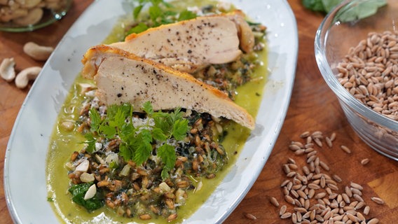 Dinkel-Risotto mit Spinat und Hühnerfleisch auf einem Teller serviert © NDR Foto: Florian Kruck