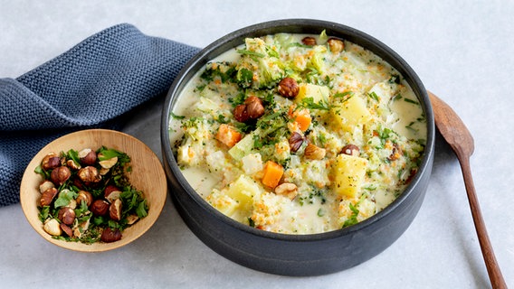 Eine Schüssel mit Gemüsesuppe, daneben ein Schälchen mit Nüssen. © ZS-Verlag Foto: Claudia Timmann