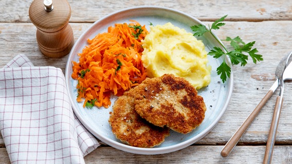 Ein Teller mit einem Haferflockenschnitzel, Kartoffelpüree und Karottensalat. © NDR Foto: Claudia Timmann