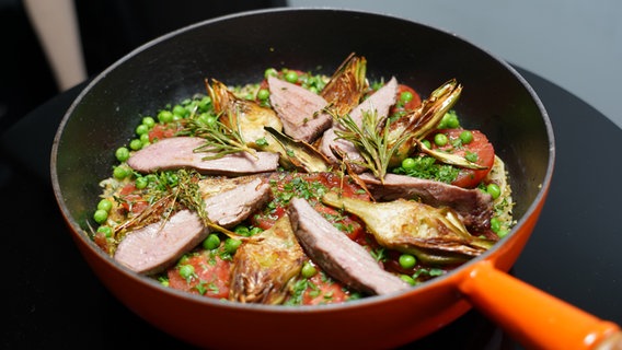 Lammfilets mit Artischocken, Tomaten, Erbsen und Bulgur in einer Pfanne © WDR/2Bild GmbH 