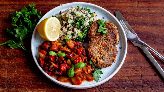 Ein Teller mit Linsenfrikadellen, Schmorgurkengemüse und Kräuter-Quinoa. © NDR Foto: Claudia Timmann