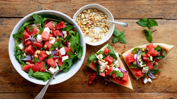 Eine Schale mit einem Melonen-Rucola-Salat, daneben ein Schälchen mit Pinienkernen. © NDR Foto: Claudia Timmann