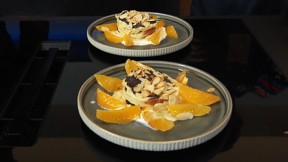 Brioche-Türmchen mit Mohnfüllung und Orangenfilets auf Tellern angerichtet © NDR 