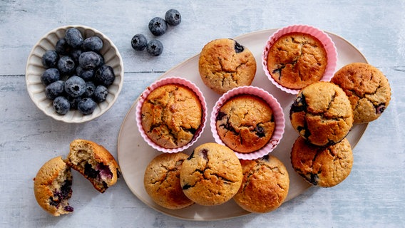 Ein Teller mit Buttermilch-Muffins, daneben eine Schale Blaubeeren. © NDR Foto: Claudia Timmann