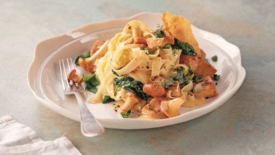 Tagliatelle mit Pfifferlingen und Huhn auf einem Teller serviert © www.westermann-buroh.de Foto: Jan-Peter Westermann