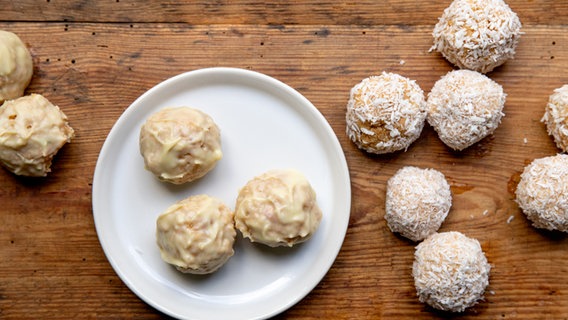 Butterkeks-Pralinen mit Kokoskruste auf einem Holztisch © NDR Foto: Claudia Timmann