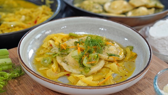 Ricotta-Kartoffel-Ravioli mit Orangenfenchel auf einem Teller serviert. © NDR Foto: Florian Kruck