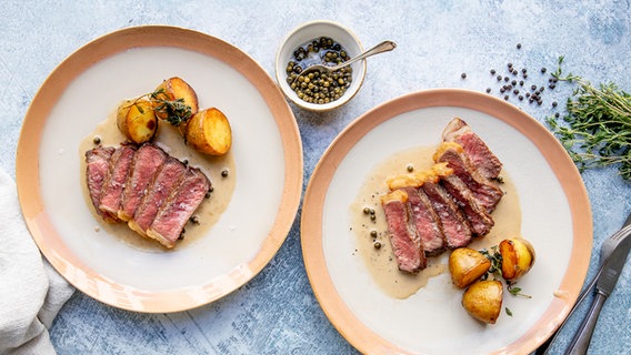 Zwei Teller mit Rumpsteak, Pfeffersoße und knusprigen Kartoffeln © NDR Foto: Claudia Timmann