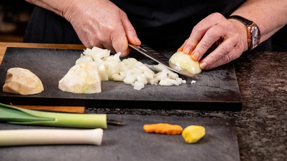 Eine Köchin schneidet Zutaten für eine Suppe klein. © NDR Foto: Claudia Timmann