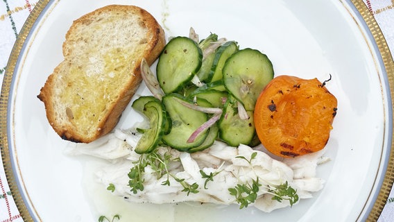 Steinbutt mit Röstbrot, Aprikose und Gurkensalat auf einem hellen Teller © NDR 