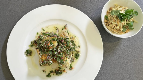 Stubenküken mit Salsa auf einem weißen Teller und eine kleine weiße Schale mit Weißkohl-Möhren-Salat © NDR 