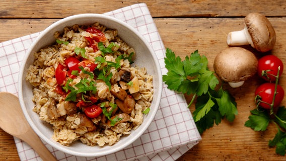 Ein tiefer Teller mit einem  Tomaten-Champignon-Porridge. © NDR Foto: Claudia Timmann