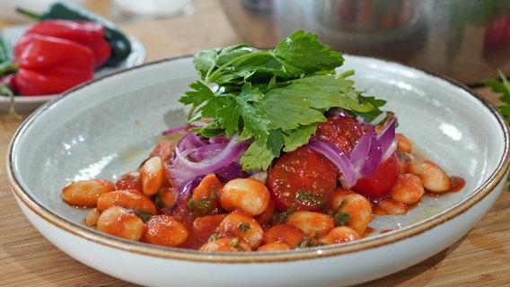 Weiße Bohnen mit Tomaten, Soße und Kräutern auf einem tiefen Teller © NDR Foto: Florian Kruck