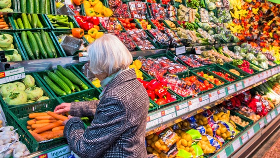 Eine Kundin steht in einem Lebensmittelmarkt am Gemüseregal. © picture alliance / ZB Foto: Jens Büttner