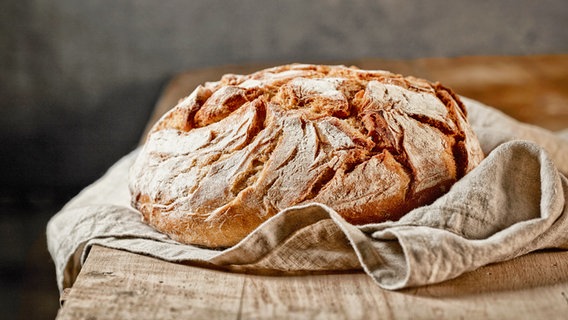 Ein frisch gebackenes Brot liegt auf einem Tuch. © Colourbox 