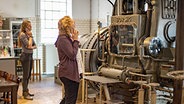 Zwei Besucherinnen mit Audioguide stehen im Industriemuseum Elmshorn vor einer Dampfmaschine. © Industriemuseum Elmshorn Foto: Peter Eberle