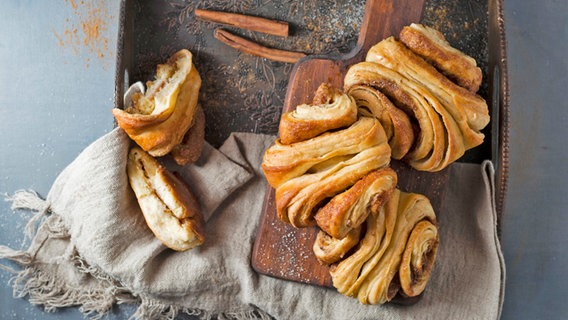 Frisch gebackene Franzbrötchen auf einem Holzbrett. © picture alliance / Westend61 Foto: Mandy Reschke