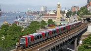 Eine U-Bahn fährt auf dem Hafenviadukt an den Hamburger Landungsbrücken vorbei. © Hamburger Hochbahn 