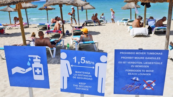 Schilder am Strand von Arenal auf Mallorca weisen im August 2020 auf die geltenden Corona-Regeln hin. © picture alliance/Clara Margais/dpa 