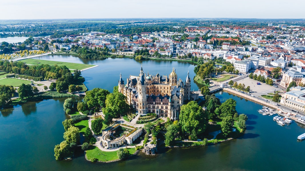 Luftaufnahme von Schwerin und dem Schweriner See mit dem Schloss im Vordergrund.
