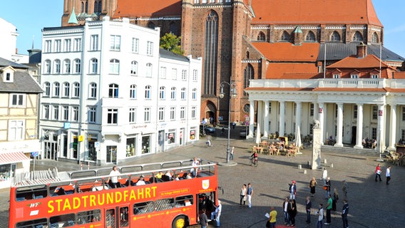 Ein roter Doppeldeckerbus steht am Marktplatz vor dem Dom in Schwerin. © Andreas Duerst, Studio301 Foto: Andreas Duerst