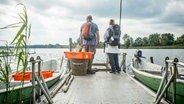 Ein Mann und eine Frau mit Rucksack blicken auf einen See. © Pilgerweg Mecklenburgische Seenplatte 