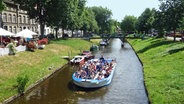 Ein Boot mit Touristen fährt in Friedrichstadt auf einer Gracht. © NDR Foto: Kathrin Weber