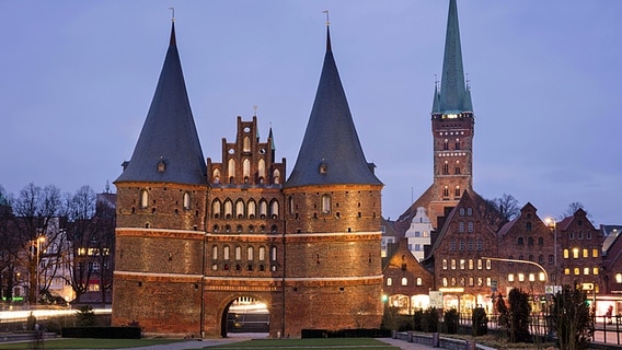 Das Holstentor in Lübeck und die St. Petri Kirche am Abend © imago/imagebroker 