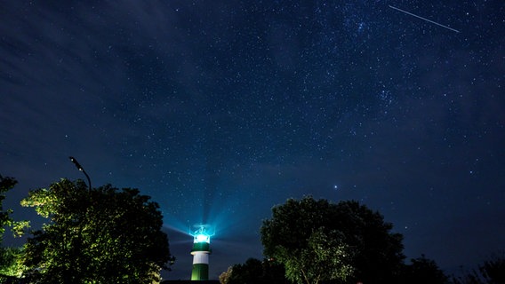 Eine Sternschnuppe über dem Leuchtturm Bülk am Ufer der Ostsee. © picture alliance/dpa Foto: Axel Heimken