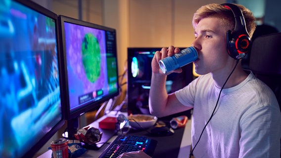 Ein Teenager trinkt einen Energydrink vor dem Computer. © Colourbox Foto: by #821