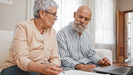 Eine ältere Frau und ein älterer Mann sitzen vor einem Laptop und einem Dokument © colourbox Foto: Peopleimages.com