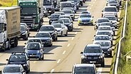 Ein Polizeiwagen fährt auf der Autobahn durch eine Rettungsgasse. © imago images / Arnulf Hettrich 